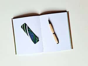 Carnet DJINDJA vue intérieure sur pages avec stylo en bois et marque pages en bois peint.