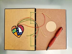 Carnet NORA vue intérieur sur page de garde et marque-pages en bois et stylo en bois.